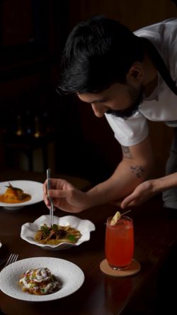 Chef plating dishes with intricate presentation at Junoon, an upscale Indian restaurant with fine dining atmosphere.