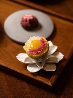 Two plated desserts served on a wooden surface at Junoon, an upscale fine dining Indian restaurant in New York.