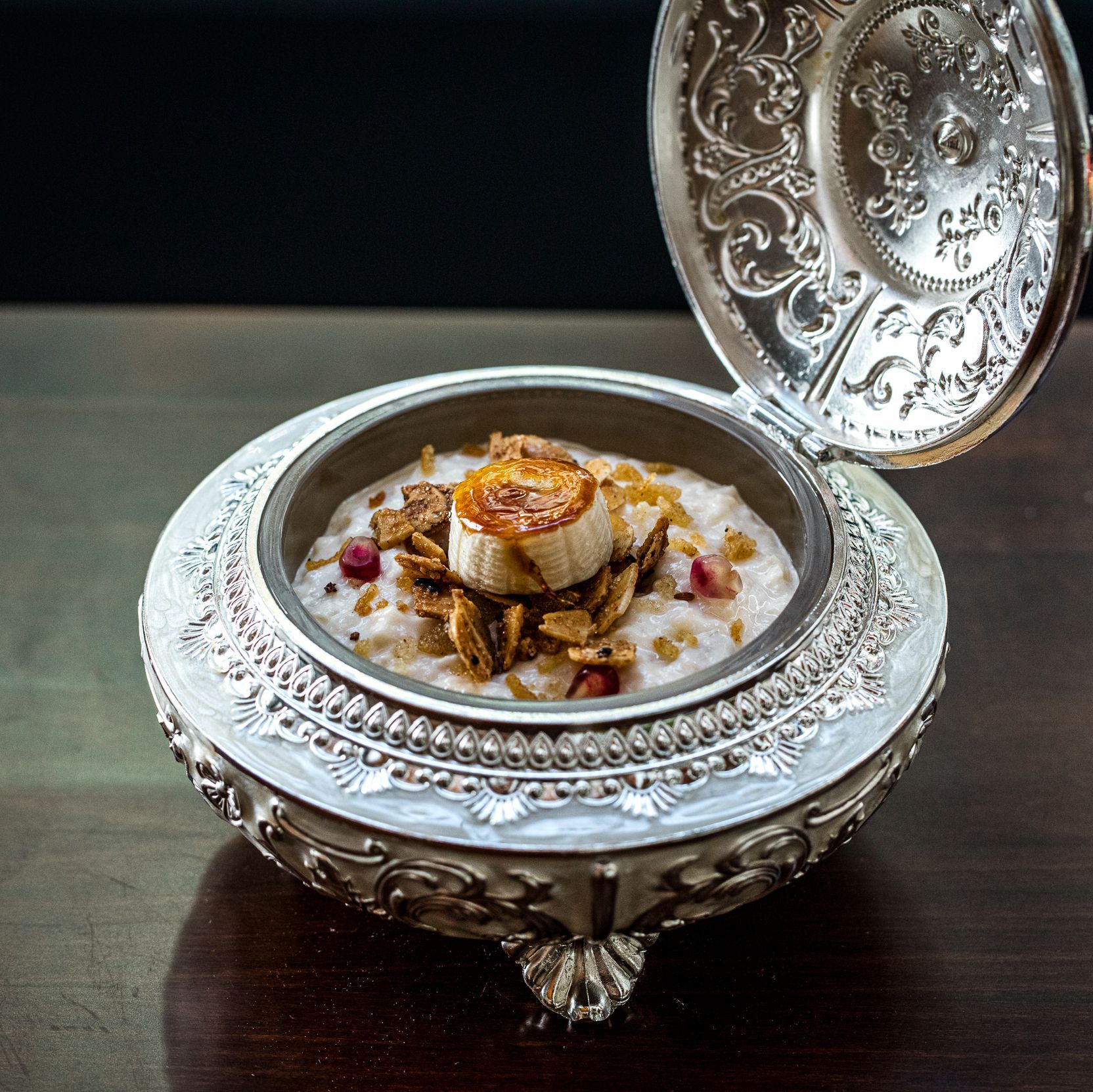 Traditional Indian dessert served in an ornate silver bowl with intricate floral patterns at Junoon restaurant.